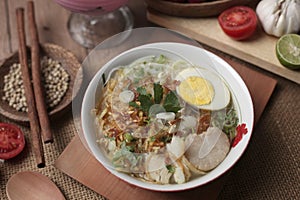 Indonesian chicken soto or soto ayam, served with ketupat or lontong photo