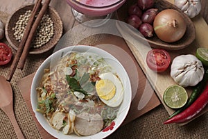 Indonesian chicken soto or soto ayam, served with ketupat or lontong photo