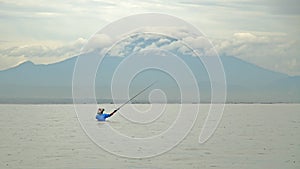 Indonesian fisherman catches a fish during.