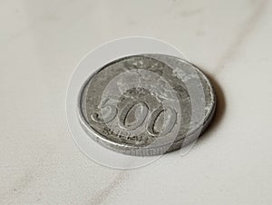 Indonesian five-hundred rupiah coin with jasmine image and dull silver color