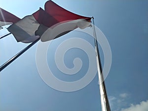 Indonesian flag flying on pole to commemorate independence day 76 years ago in Senayan, South Jakarta, Indonesia