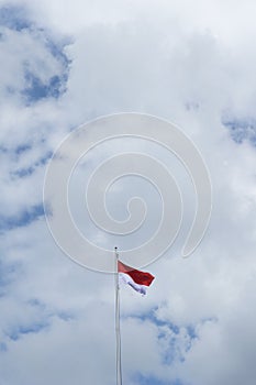 Indonesian flag isolated on blue sky with clipping path. close up of flying the red and white flag