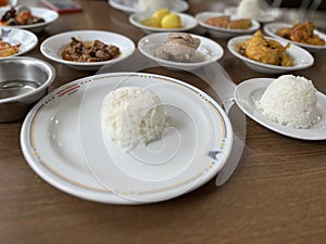 Indonesian food, authentic Padang cuisine, fried chicken, rendang, with white rice