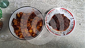 indonesian food kentang balado or french fries couting with chili sauce and beef rendang
