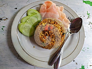 Indonesian food, Nasi Goreng kampung or fried rice, served with cucumber and crackers
