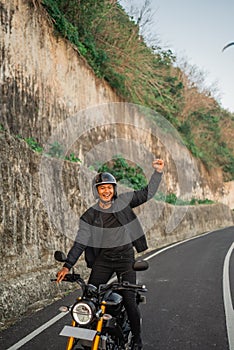 indonesian man standing motorcycle fist pump gesture