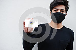 Indonesian man wear all black with face mask hold Central Sulawesi flag in hand isolated on white background. Provinces of