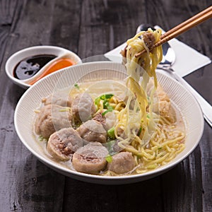 Indonesian Meatball Bakso Noodle with sweet soy sauce and chilli sauce sprinkle with green onion photo