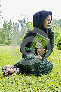 Indonesian moslim girl with a quran photo