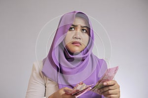 Indonesian muslim woman confused how to spend her money earning