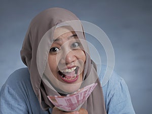 Indonesian Muslim Woman Holding Rupiah Money