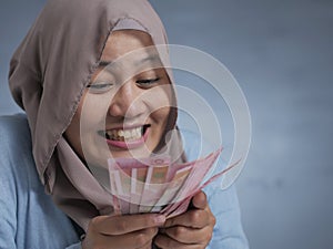 Indonesian Muslim Woman Holding Rupiah Money