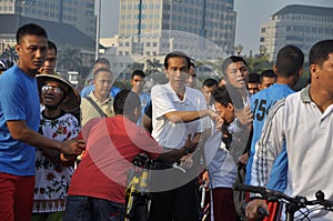 Indonesian President Joko Widodo while cycling greets residents