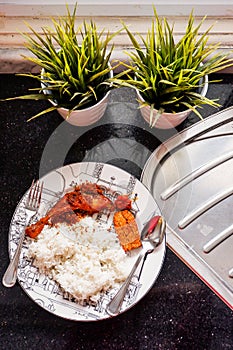 Indonesian style dish including white rice, fried chicken with serundeng shredded fried coconut, and sambal paste put on a plate