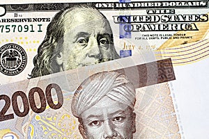An Indonesian two thousand rupiah bill will an American one hundred dollar bill