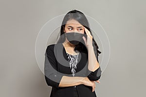 Indonesian woman wearing black mask holding head