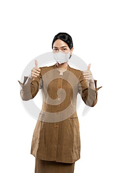 Indonesian women in civil servant uniforms wearing masks thumb up