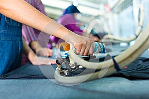 Indonesian worker with flat iron in textile factory