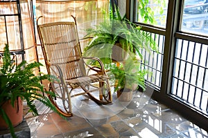 indoor balcony with bamboo rocking chair and potted ferns