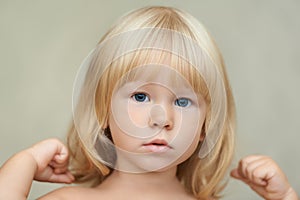 Indoor casual portrait of a serious child making physical exercises