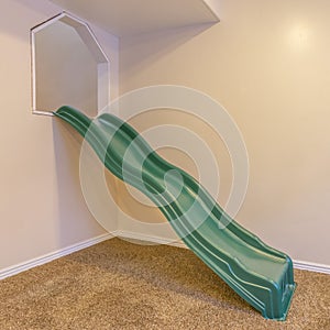 An indoor childrens playground with green slide