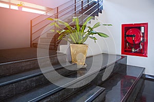 indoor concrete staircase with fire extinguisher and fire hose reel