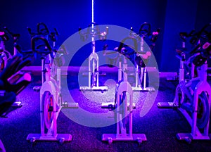 An indoor cycling dance class in a blue LED lighting room