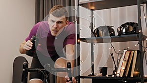 Indoor cycling. Man is training on stationary bicycle, preparing for triathlon and cycling races. Cyclist is cycling on smart trai