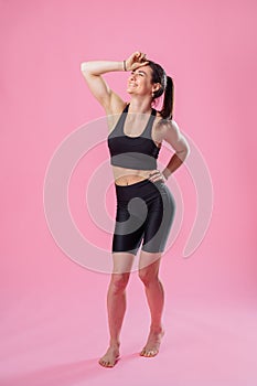 Indoor fashion portrait of a young caucasian brunette beautiful woman. Fun and cute smiling, wearing a sexy casual black sports