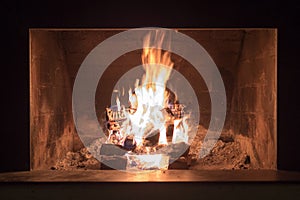 Indoor fireplace at night with bright flames