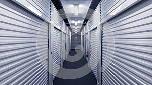 Indoor hallway with metal storage unit doors on each side.