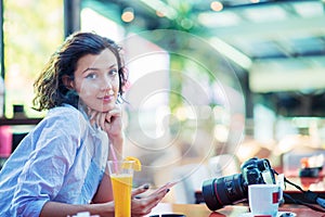 Indoor lifestyle fashion portrait of beautiful woman posing at cafe.