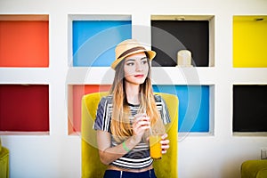 Indoor lifestyle portrait of beautiful woman posing at cafe, drinking fresh healthy tasty juice, smiling, have nice time.