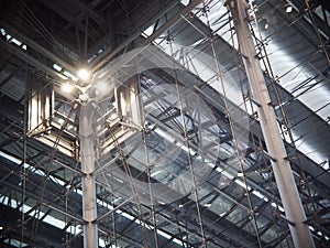 Indoor modern contemporary complex steel wall and roof construction structure inside a large building with bright illumination hig