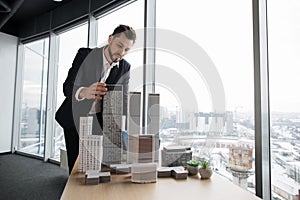 Indoor office portrait of bearded young business man, wearing white shirt and black suit