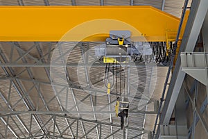 Indoor overhead crane on a yellow steel beam