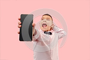 Indoor portrait of attractive young boy holding blank smartphone