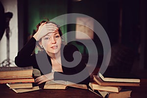 Indoor portrait of beautiful redhead woman learning or reading books in university