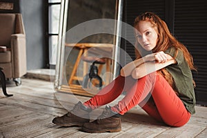 Indoor portrait of beautiful young redhead woman