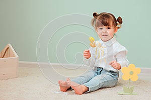 Indoor portrait of cute happy baby girl playing with easter decorations