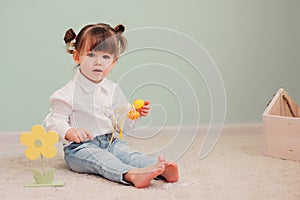 Indoor portrait of cute happy baby girl playing with easter decorations