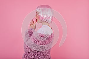 Indoor portrait of pensive inspired woman wears periwig and fluffy purple coat. Studio photo of joc