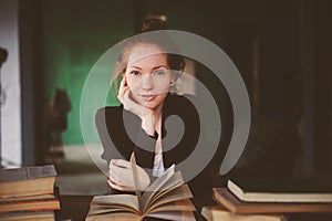 Indoor portrait of redhead happy student woman learning or reading books