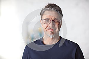 Indoor portrait of white older man with gray hair, wearing eyewear