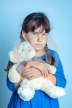 Indoor portrait of young child girl with teddy bear, studio shot