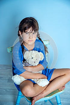 Indoor portrait of young child girl with teddy bear, studio shot