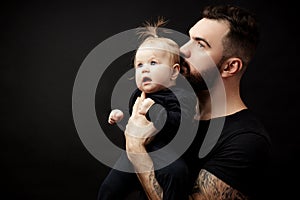 Indoor portrait of young father hugging his little daughter