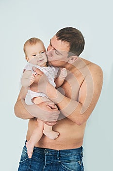 Indoor portrait of young father hugging his little toddler daughter. family, fatherhood and people concept. father& x27;s day.