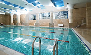 Indoor public swimming pool interior in fitness gym club