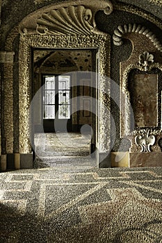 Indoor room of historic white & black pebbled floor, walls and ceiling with geometric patterns from Palace northern Italy